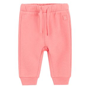 Pink sweatpants with elastic around the ankles and cord on the waist